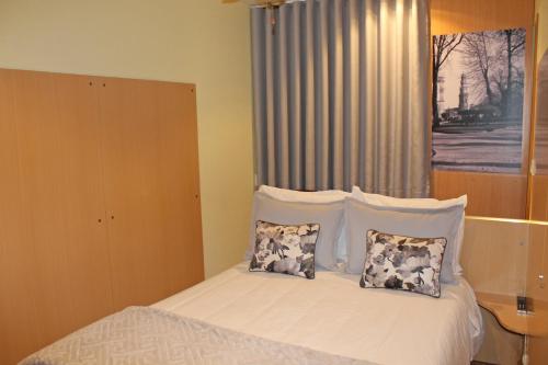 a bedroom with a bed with white sheets and pillows at Residencial Paranhos in Porto