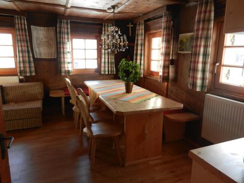 a dining room with a wooden table and chairs at Berghütte Schöpf in Umhausen