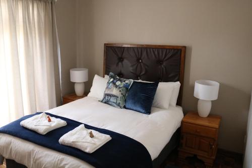 a bedroom with a large bed with two towels on it at Caledon Overnight Rooms in Kimberley