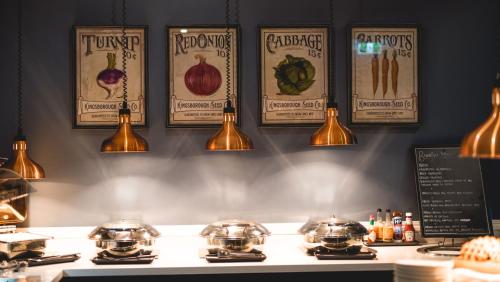 a counter with pots and pans and lights on a wall at voco™ Kirkton Park Hunter Valley, an IHG Hotel in Pokolbin