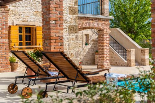 two benches sitting in front of a building at Villa Romantika Dalmacija in Nin