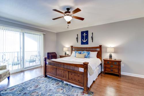a bedroom with a bed and a ceiling fan at Sleek Gulfport Condo with Ocean Views and Pool Access! in Gulfport