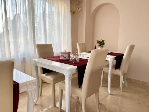 a dining room table with white chairs and a red table cloth at Il Castellaccio in Spello