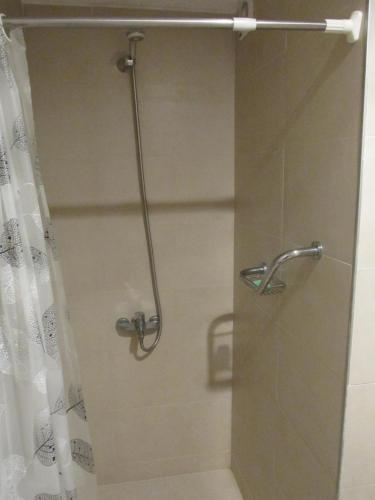 a shower with a glass door with a shower curtain at Ayres del Puerto in Punta del Este