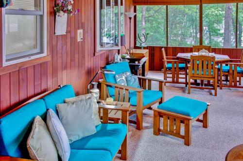 a room with blue couches and tables and chairs at Hike, Fish and Boat Waterfront Home in Brainerd! in Brainerd
