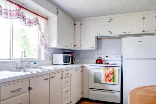 a kitchen with white cabinets and a white refrigerator at Charming Tropic Home by a Farm Near Bryce Canyon! in Tropic