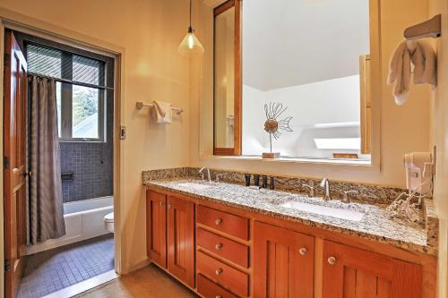 a bathroom with a sink and a mirror and a tub at Hot Tub and Grilling Area Keystone Townhome! in Keystone