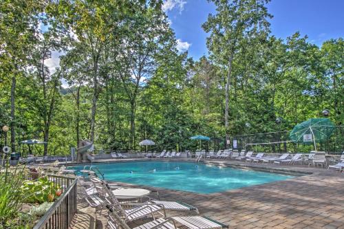 a swimming pool with lounge chairs and a table at Cabin with Hot Tub 2 Mi to Downtown Gatlinburg! in Gatlinburg