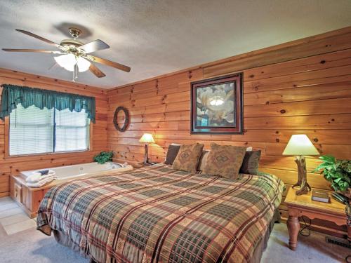 1 dormitorio con cama, bañera y ventilador de techo en Idyllic Cabin with Hot Tub Less Than 2 Mi to Dollywood! en Sevierville