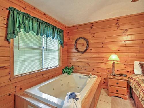 Habitación con paredes de madera y baño con bañera. en Idyllic Cabin with Hot Tub Less Than 2 Mi to Dollywood! en Sevierville