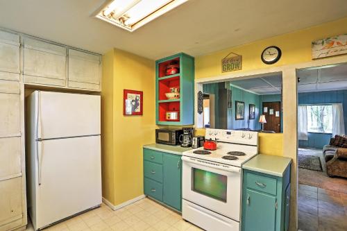 a kitchen with green cabinets and a white refrigerator at Quiet Durango Farmhouse with Beautiful Yard and Gazebo in Durango