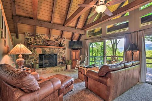 a living room with leather furniture and a stone fireplace at Sky Valley Home with Stunning Views - 1 Mi to Resort in Sky Valley