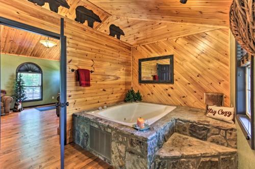 une salle de bain avec une baignoire dans un mur en bois dans l'établissement Sevierville Overlook Cabin 9 Miles to Gatlinburg!, à Sevierville