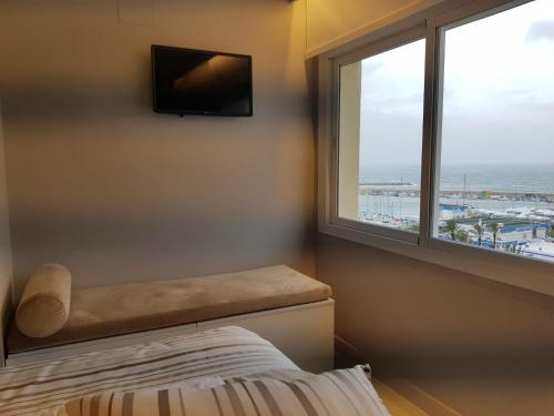 a bedroom with a window with a view of the ocean at FABULOUS APARTMENT IN FRONT OF SEA & MARINA WITH INCREDIBLE VIEWS in Estepona