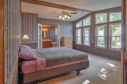 a bedroom with a bed and a dresser and windows at Captivating Cadiz Hideaway with Deck on Lake Barkley in Cadiz