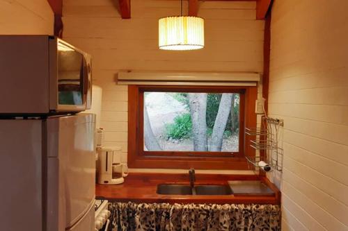 cocina con fregadero y ventana en Cabaña de montaña en Bosque Nativo en San Carlos de Bariloche