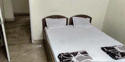 a bed with two pillows on it in a room at Adarsh lodge in Jamshedpur