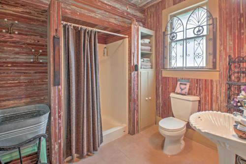 a bathroom with a toilet and a sink and a window at August Schmidt Fredericksburg Cottage with Hot Tub in Fredericksburg