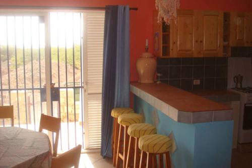 a kitchen with a counter with stools in it at Kasa Mona in Calheta Do Maio