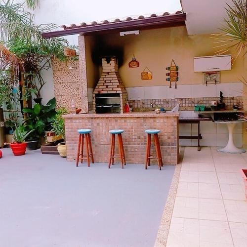 a kitchen with stools at a bar in a patio at Pousada Solar de Lourdes in Guarapari