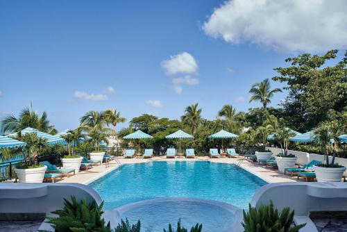 a pool with lounge chairs and umbrellas at a resort at La Samanna, A Belmond Hotel, St Martin in Baie Longue