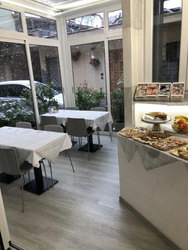 a kitchen with two tables and a counter with food at Hotel City in Chivasso