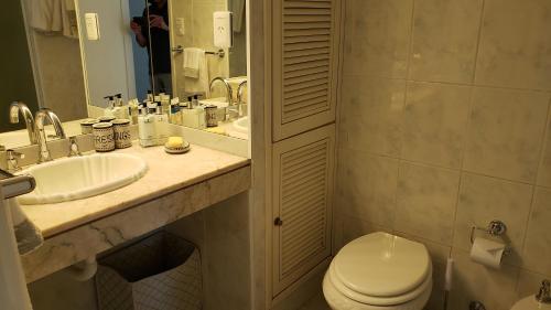 a bathroom with a toilet and a sink and a mirror at Amazing Oceanfront unit on Mansa Beach in Punta del Este