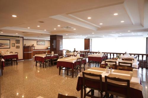 イスタンブールにあるヤウス ホテルのテーブルと椅子、大画面のレストランを併設しています。