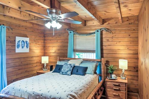 a bedroom with a bed and a ceiling fan at Lake Broward Cabin with Private Boat Launch and Dock! in Satsuma