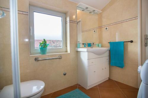 een badkamer met een toilet, een wastafel en een raam bij KALA Main Square Poreč in Poreč