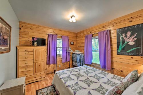 a bedroom with wooden walls and purple curtains and a bed at Cozy Colorado Cabin with Deck, Grill and River Access! in Buena Vista