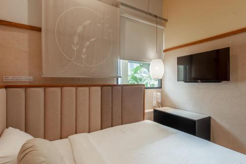 a bedroom with a bed and a flat screen tv at Bunk & Bilik Hotel Sri Petaling in Kuala Lumpur