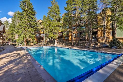 a swimming pool in front of a house with trees at Walk to Lifts! SnowDogs Breck Condo with Fireplace in Breckenridge