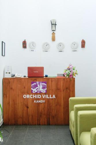 a reception desk with a laptop on top of it at Orchid Villa Kandy in Kandy
