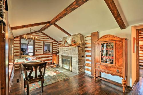 a living room with a stone fireplace and a table at Macungie Cabin with Fireplace Near Bear Creek Skiing in Macungie