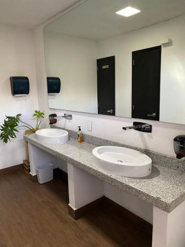 a bathroom with two sinks and a large mirror at Hotel Jiménez in Oaxaca City