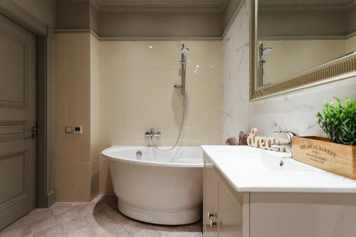 a bathroom with a bath tub and a sink at Old town Kalku Apartment in Rīga