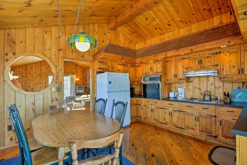 a kitchen with a table and a white refrigerator at Biddeford Retreat with Deck, Grill and Ocean Views! in Biddeford