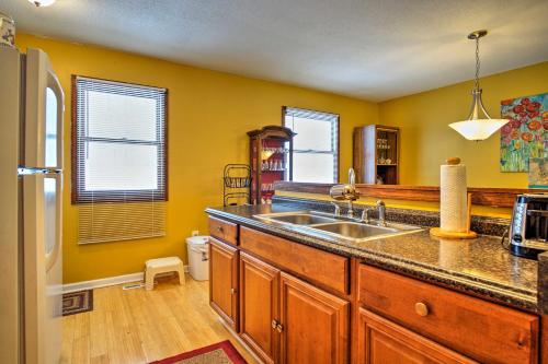 a kitchen with a sink and a refrigerator at Wooded Twin Lakes Retreat 13 Mi to Lake Michigan! in Twin Lake