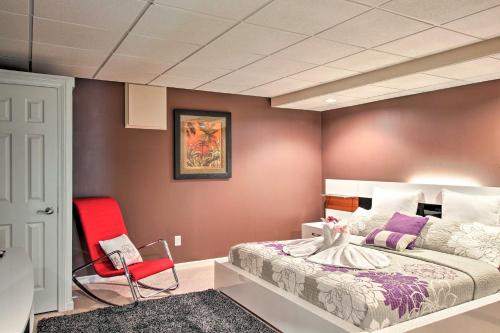 a bedroom with a large bed and a red chair at Stunning Duluth Family House with Fireplace and Patio! in Duluth