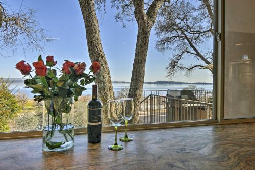 a table with two glasses and a bottle of wine and flowers at Casa dAmore Extravagant Lakefront Villa! in Granite Bay