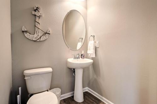 a bathroom with a toilet and a sink and a mirror at Port St Joe Beach House with Pool Access! in Port Saint Joe
