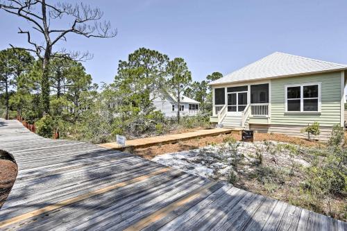 a house with a wooden deck in front of a house at Port St Joe Beach House with Pool Access! in Port Saint Joe