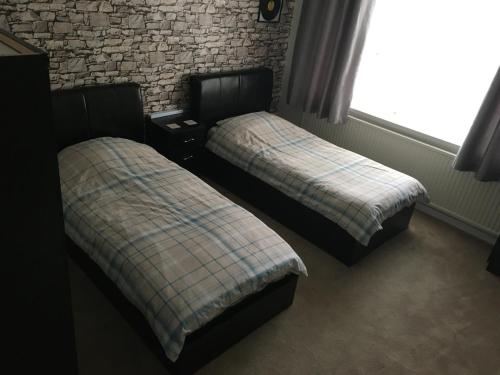 two beds sitting next to each other in a room at Nottingham City House in Nottingham