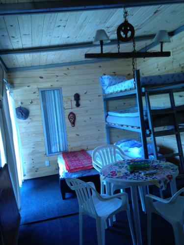 Una habitación con mesa, sillas y literas. en VI-BE-MA, en San Gregorio de Polanco