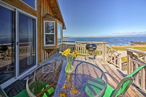 a glass table and chairs on a porch with a view of the ocean at A Room with a View Peaceful Retreat on PoW in Coffman Cove