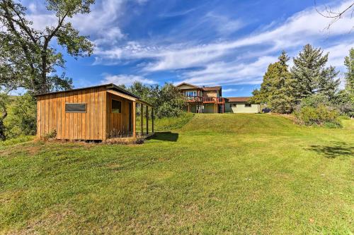 a wooden shed on a grassy hill with a house at Rapid City Vacation Home with Wraparound Deck! in Rapid City