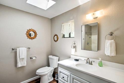 a bathroom with a sink and a toilet and a mirror at Prescott Forest Cabin with Deck, 9 Miles to Downtown in Prescott