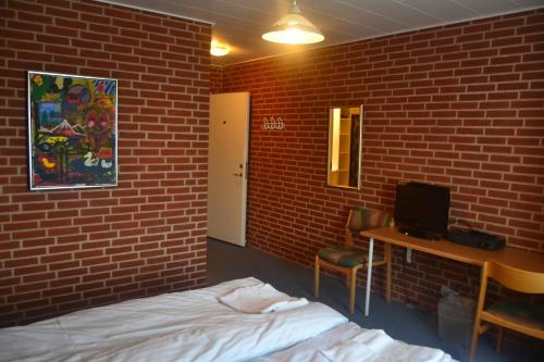 a room with a bed and a brick wall at Paarup Kro in Engesvang