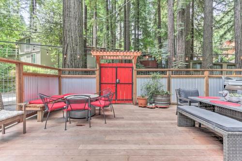 a patio with a table and chairs and a red door at Redwoods Cabin with Hot Tub Walk to Russian River! in Guerneville
